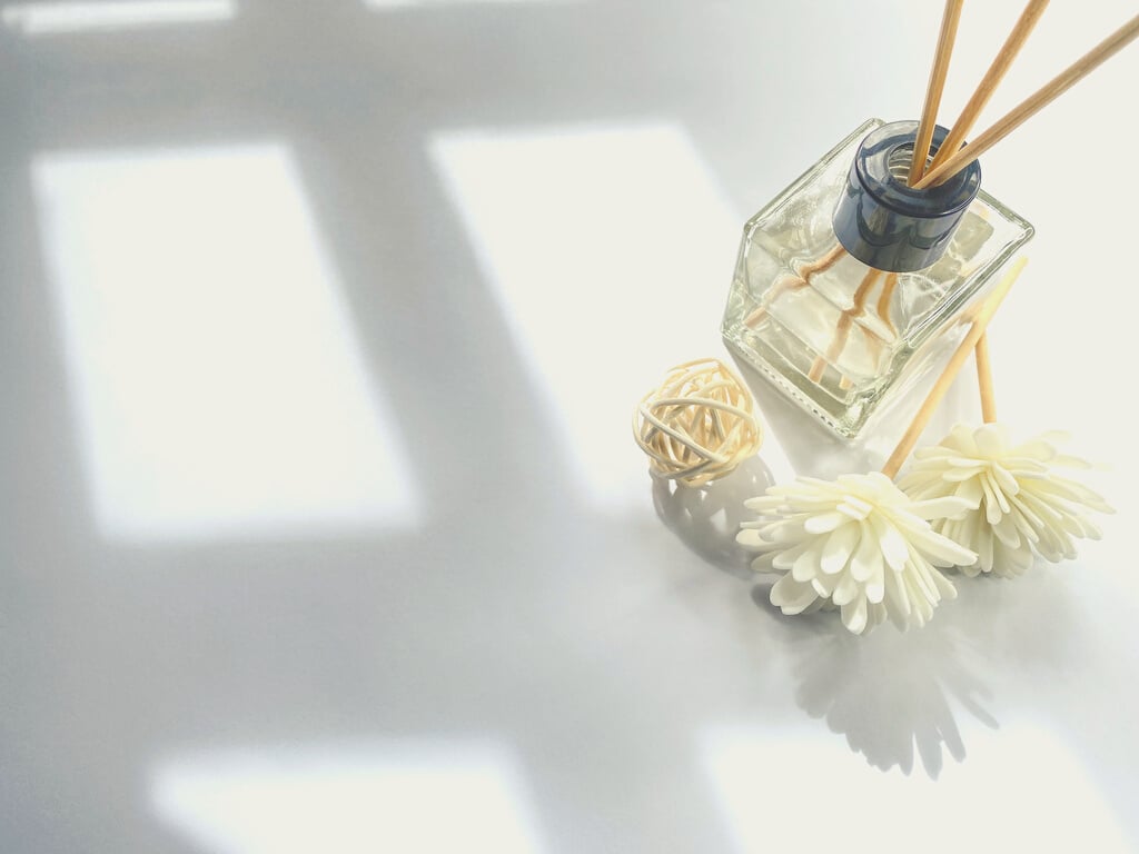 Reed Diffuser and Flowers on Table with Sunlight